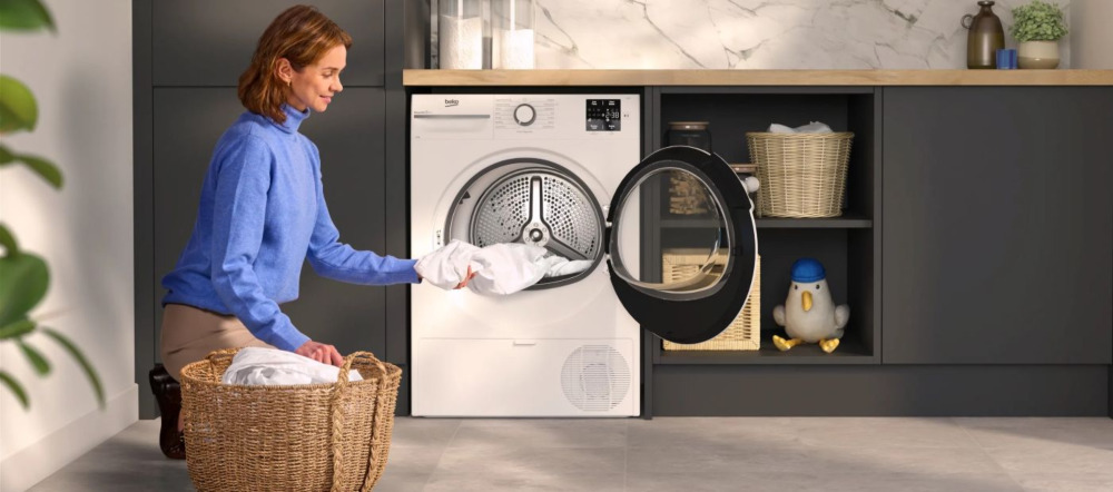 Woman unloaded clothes from a tumble dryer